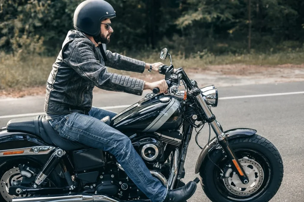 A man in leathers riding a motorcycle.