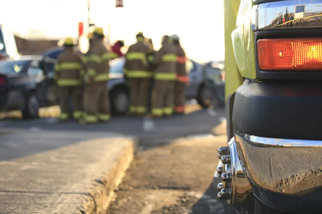 out of focus fire fighters looking at a car accident.