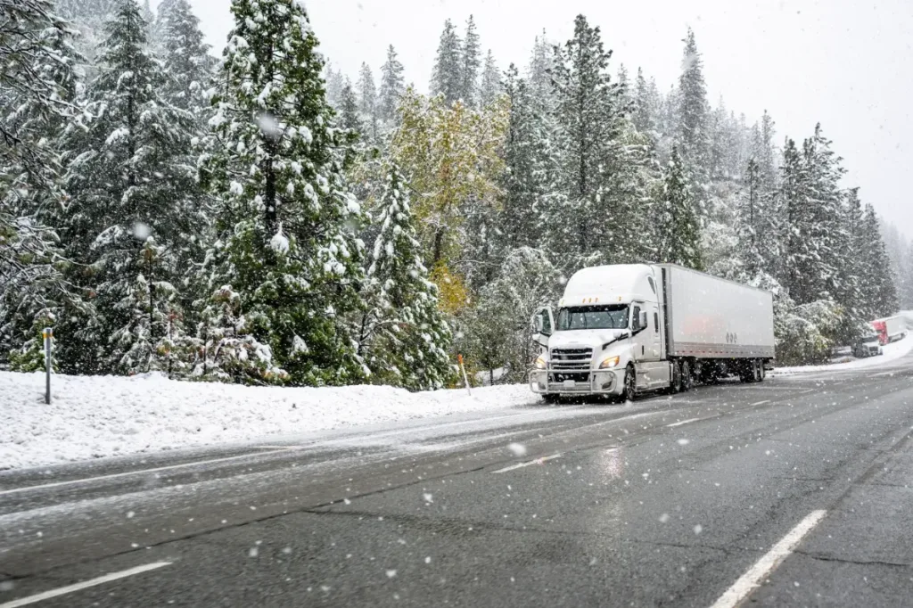Semi-truck driving in the snow.