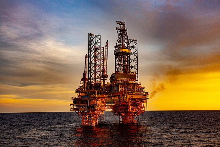 oil drilling platform at sunset