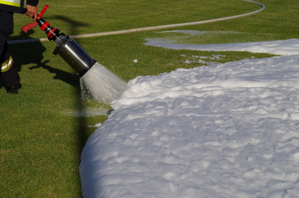 A firefighter using Aqueous Film Forming Foam (AFFF)