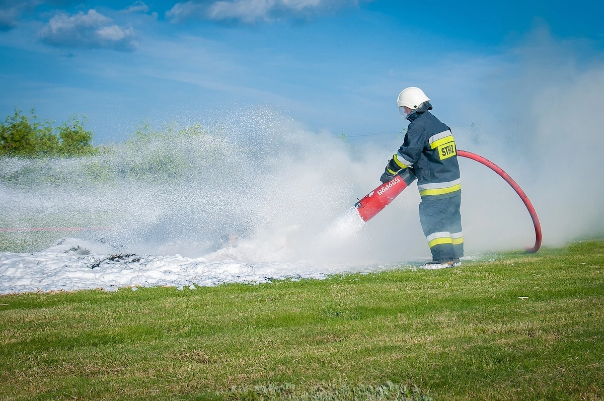 A firefighter using Aqueous Film Forming Foam (AFFF)