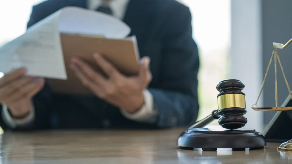 An attorney looking at paperwork with a gavel on his desk.