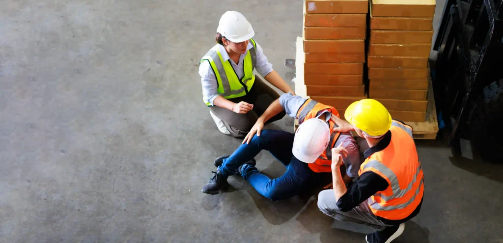 An injured worker getting help from co-workers.
