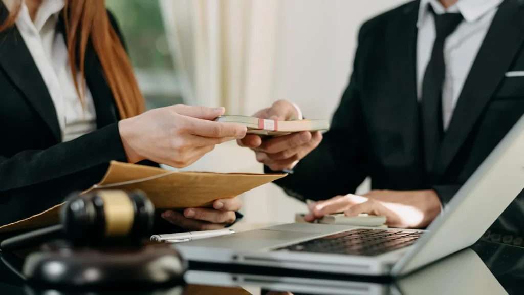 Two business people exchanging money for a settlement.